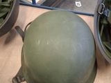 a person that is holding a helmet on a table