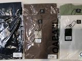 plusieurs chemises sont emballées dans des sacs en plastique, posées sur une surface blanche