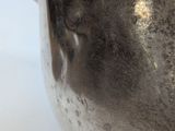 a silver vase that is sitting on a table
