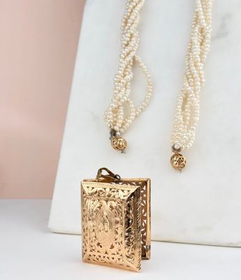 a close up of a necklace and a necklace with pearls on it