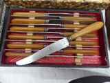 a box with six knives in it on a table