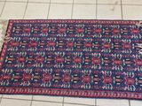 a blue and red rug sitting on top of a tiled floor