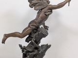 bronze statue of a woman with a torch in her hand