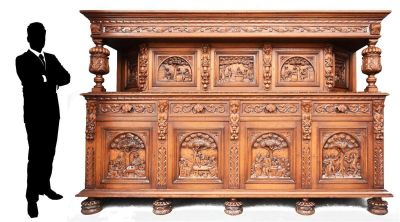 un homme debout devant une grande armoire en bois