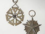 two silver metal items on a white surface one has a star and the other has a star