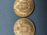two gold coins sitting on top of each other on a blue surface