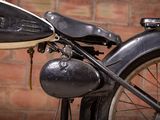 a close up of an old motorcycle parked in front of a brick wall