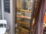 un réfrigérateur à porte vitrée dans un coin de la pièce