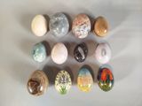 many different colored stones on a white surface