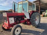 a red tractor parked in front of a building