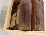 trois bouteilles vides dans une boîte en bois posée sur une table