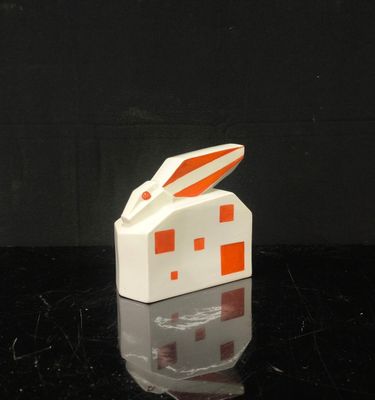 une maison blanche et orange sur le toit de laquelle se trouve un lapin
