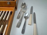 a lot of spoons and forks on the table