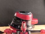 a red and black vacuum sitting on a wooden table