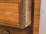 a close up of a wooden dresser with brass knobs