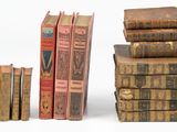 plusieurs vieux livres empilés sur une surface blanche