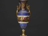 un vase bleu richement décoré, orné de bordures dorées et de motifs floraux