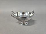 an antique silver bowl with handles and handles on a table