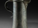 une vieille cafetière en argent surmontée d'un oiseau
