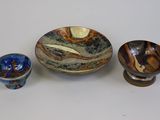 three bowls and a bowl sitting on a table next to each other