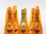 three bottles of champagne are lined up on a white surface