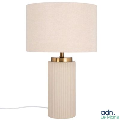 une lampe blanche avec un abat-jour beige posée sur une table