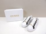 white and black sneakers with gold logo on the side of them