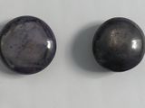 two black oval cabochles are sitting on a white surface
