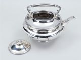 a silver teapot with a lid and a lid on a white surface