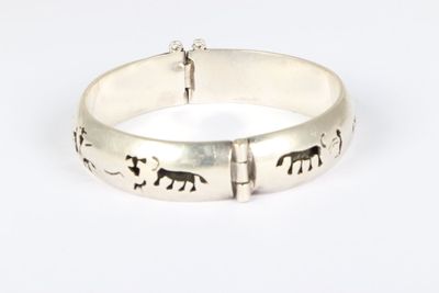 a close up of a silver bracelet with elephants on it