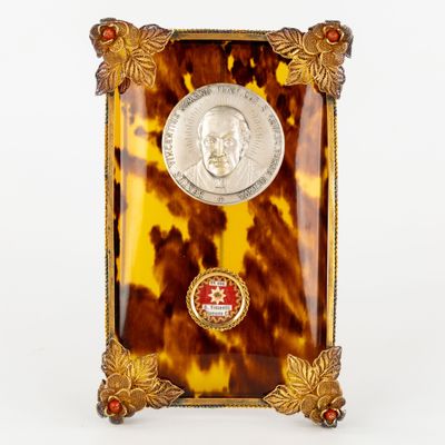 a picture of a small tortoise shell clock with a coin on it