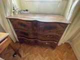 a dresser in the corner of a room with a window