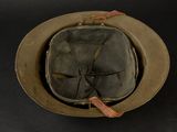 an old military helmet with a tag on it on a black surface