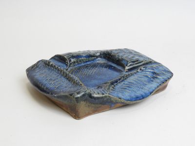 a small blue bowl on a table with a white background