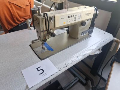 une machine à coudre posée sur une table dans une pièce