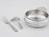 un bol en argent, avec une cuillère et une fourchette à côté