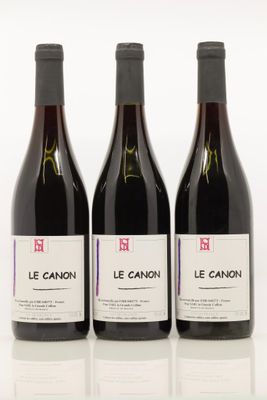 trois bouteilles de vin sont alignées sur une surface blanche