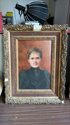 une photo d'un tableau représentant une femme, posé sur une étagère