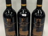 three bottles of red wine with gold designs on them on a white surface