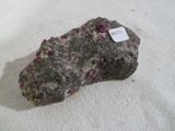 a rock with a tag on it sitting on a white surface
