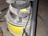 un aspirateur jaune et noir posé sur un sol sale
