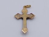 a close up of a gold cross on a white surface
