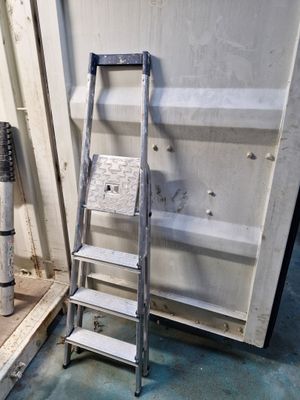 une échelle appuyée contre un mur, à côté d'une borne d'incendie