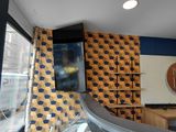 une vitrine en verre bombé dans un magasin, avec une horloge accrochée au mur