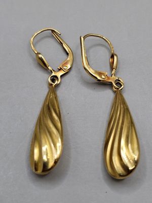 a pair of gold earrings on a white surface