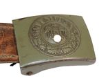 an old belt with a metal buckle with a seal on it