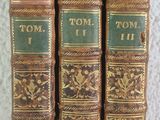 trois vieux livres posés sur une table l'un à côté de l'autre