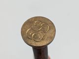 someone is holding a small wooden stick with a monogram on it