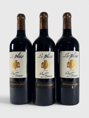 trois bouteilles de vin rouge posées l'une à côté de l'autre sur une surface blanche