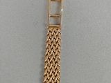 a close up of a gold watch with a chain around it